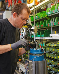 Skilled industrial worker assembling electric motors