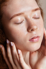a very beautiful teenage girl washed her face and closed her eyes. Young skin care concept. Shot in a studio closeup, vertical