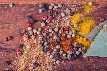 background with different color spices on wood background