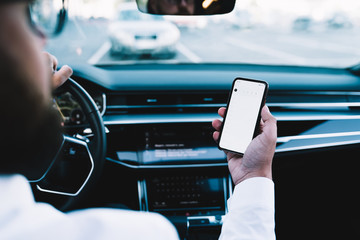 Back view of executive driver using cellphone technology for tracking gps location via smartphone...