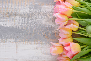top view pink tulips with yellow tint on light wooden background