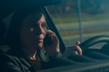 Businesswoman talking on mobile phone in the car