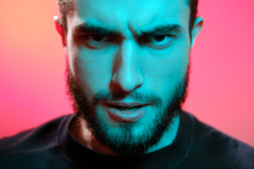 Beautiful caucasian young man portrait isolated on multicolored neon light backgroud. Young, smiling, surprised, screaming. Human emotions, facial expression concept. Trendy colors.Advertising concept