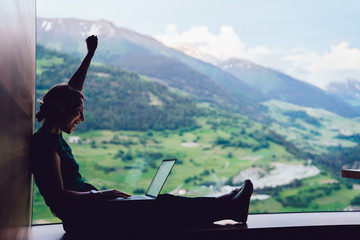 Side view of accomplished digital nomad celebrating lottery online win during networking time on...
