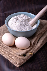 A bowl of flour with eggs