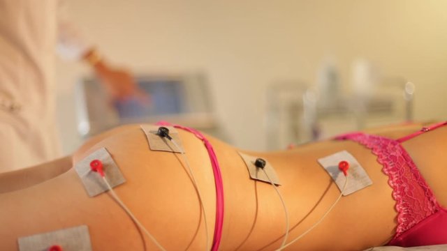 Close up of woman getting electro stimulation therapy of the butt and leg. Hardware cosmetology and antiage therapy.