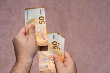 Hand holding showing euro money and giving or receiving money like tips, salary. 50 EURO banknotes...