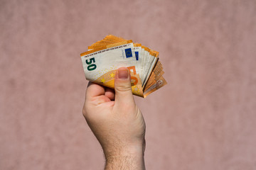 Hand holding and showing a fan of euro money or giving money. World money concept, 50 EURO...