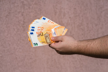 Hand holding and showing a fan of euro money or giving money. World money concept, 50 EURO...