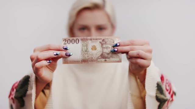 Blonde lady showcasing Hungarian Forint currency note