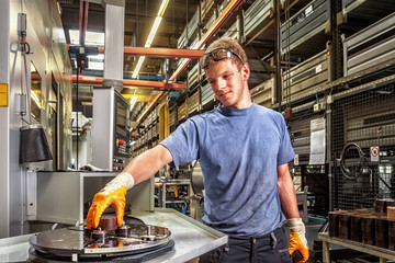 Skilled worker controlling a digitally programmed machine tool