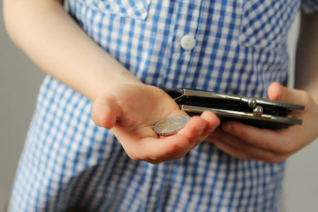 kid holds euro coins and black wallet in his hand, concept of pocket money, theft, shopping