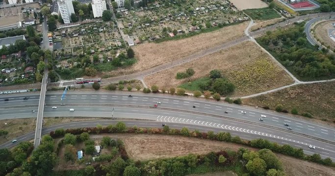 Aerial view of city landscape with autobahn motorway in metropolis, Bird's eye. Automobiles moving at street with modern automotive expressway. interchange road highway, junctions freeway