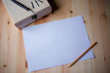 Paper and objects for writing and drawing lie on the surface of the table.