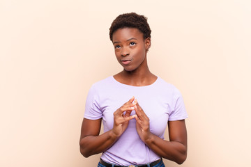 young pretty black womanscheming and conspiring, thinking devious tricks and cheats, cunning and...