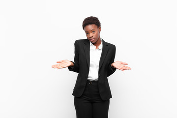 young pretty black womanfeeling puzzled and confused, unsure about the correct answer or decision,...