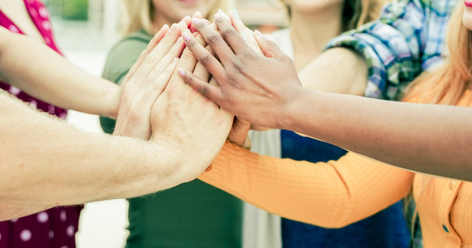 Young people putting their hands together. Friends with stack of hands showing unity and teamwork. Group of people assembly hands as business or work achievement. Man and women touch each other hands 
