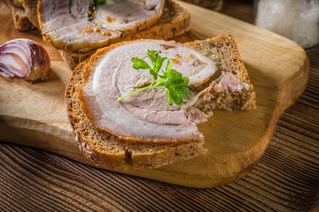 Tasty breakfast - dark bread with baked bacon.