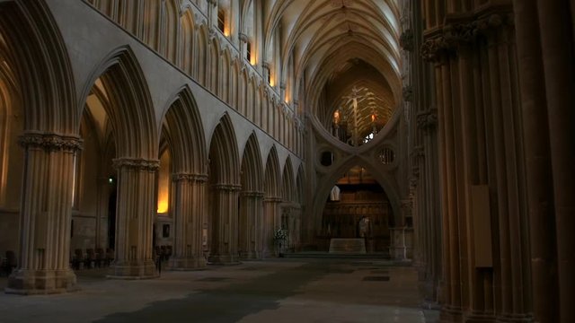 Stunning, smooth gliding shot looking down the spectacular nave inside Wells Cathedral, with its stuning arches and vaulted ceiling, in Wells, England
