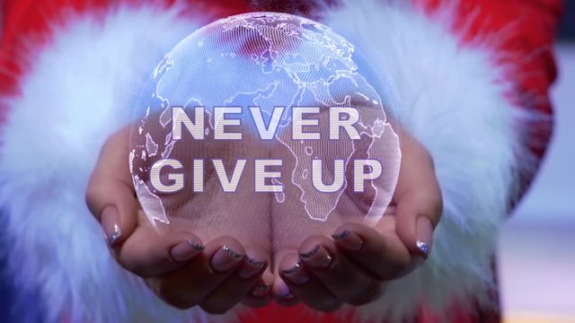 Female hands holding a conceptual hologram of planet Earth with text Never give up. Woman in red clothes with faux white fur with future holographic technology