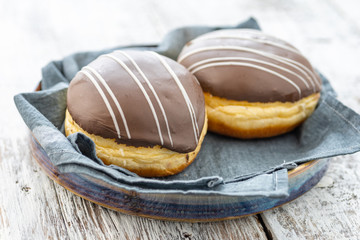 Donut or bun made from sweet yeast dough stuffed with chocolate and icing. Confectionery - Berliner Pfannkuchen.