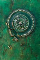 Fototapeta na wymiar The walls with relief decorative plaster and round bas-relief are painted in malachite-green paint with Golden-yellow streaks. Green vintage background.