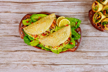 Corn soft tortillas stuffed with lettuce, meat and cheese on wooden background. Mexican dish.