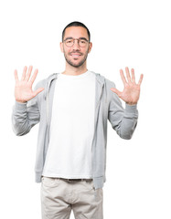 Young man making a number ten gesture