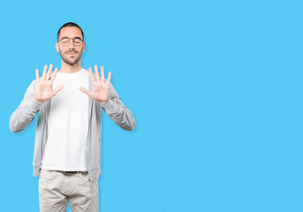 Young man making a number ten gesture