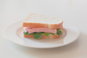 fresh ham, cheese  and salad sandwich traditional italian tramezzino rest on a white plate with copy space for your text