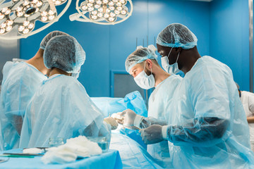 The senior surgeon in the operating room, where the patient is waiting for him, and he begins the operation. Real Modern Hospital with Authentic Equipment.