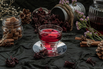Roselle tea (Jamaica sorrel, Rozelle or hibiscus sabdariffa ) with dry roselle and brown cane sugar cube.