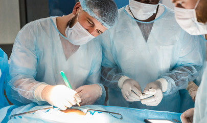 The senior surgeon in the operating room, where the patient is waiting for him, and he begins the operation. Real Modern Hospital with Authentic Equipment.