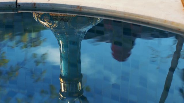 man smokes hookah on the edge of the pool. gold plated hookah detail. bubbling of hookah juice.