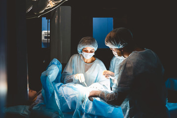 The senior surgeon in the operating room, where the patient is waiting for him, and he begins the operation. Real Modern Hospital with Authentic Equipment.