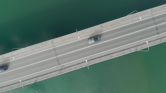 Aerial time lapse urban traffic scene car drive fast on a bridge over the green water river