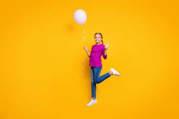Fototapeta na wymiar Full length body size view of her she nice attractive lovely cheerful cheery girl jumping holding in hand air ball showing v-sign, isolated on bright vivid shine vibrant yellow color background