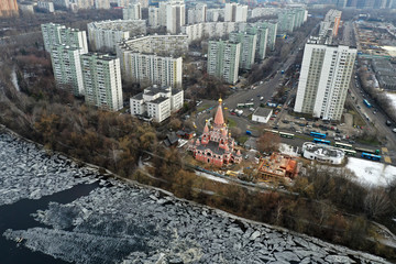 red brick church with golden baths near the river against a city background shot from a quadrocopter