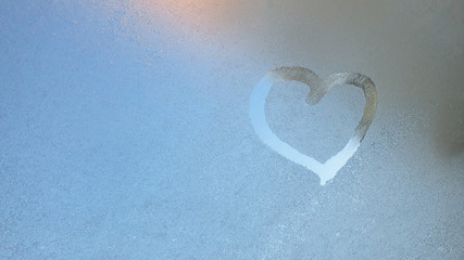 heart drawn on Frost on glass in winter