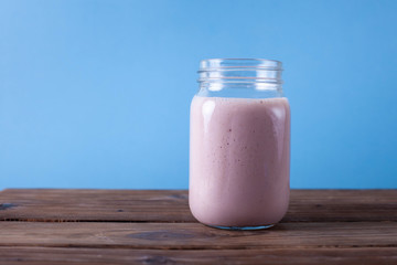 Fresh pink smoothie on a blue pastel background. Copy space. 