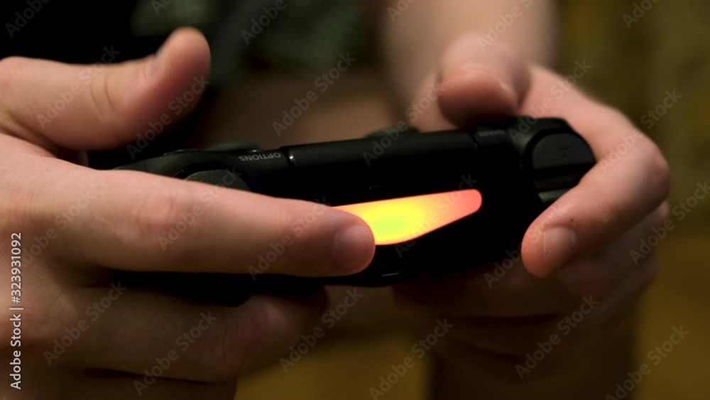 Poster young man hands holding a remote control from a game console and pressing buttons. concept. close up