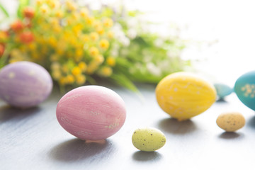 Easter eggs decoration with and flowers on a gray wooden table.