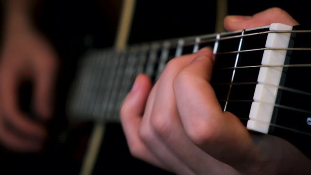 Close up of man hands masterly playing chords. Concept. Musician plaing acoustic guitar, composing music in rock genre.