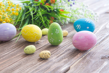 Easter eggs painted in pastel colors on a wooden background