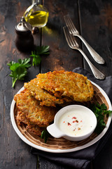 Draniki - potatof ritters, vegetarian potato pancakes, served with fresh herbs and garlic yogurt sauce, selective focus.