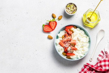 Healthy breakfast bowl, cottage cheese with strawberry and almonds and honey. Top view, copy space.