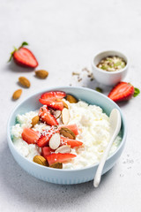 Healthy breakfast bowl, cottage cheese with strawberry and almonds, sesame seeds, honey. Selective focus, copy space.