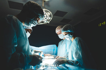 An international professional team of surgeon, assistants and anesthesiologist perform a complex...
