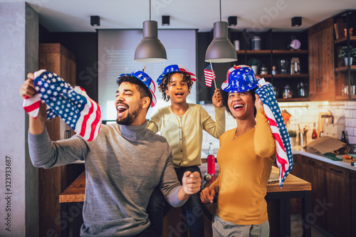 Family in living room on fourth of July with flags smiling