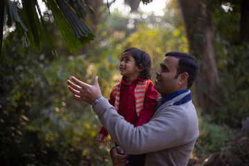 An Indian brunette father and his baby boy in winter garments enjoying themselves in winter...